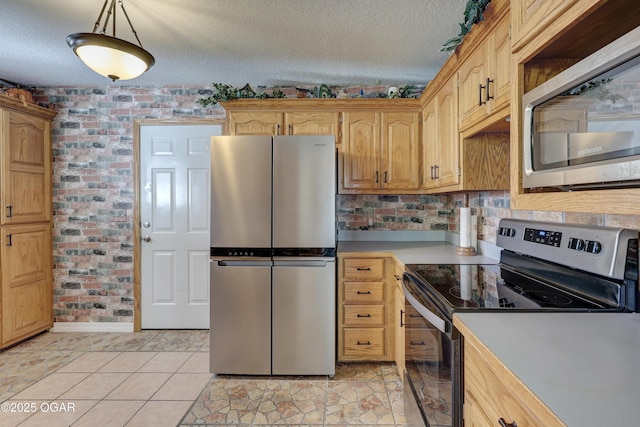 505 W Gault St, Carl Junction, MO 64834 - kitchen with appliances with stainless steel finishes, light countertops, a textured ceiling, and brick wall