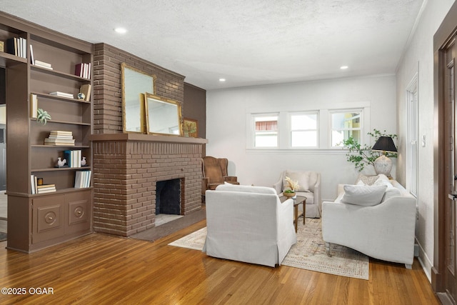 2716 E 14th St, Joplin, MO 64801 - living room featuring wood finished floors, a fireplace, a textured ceiling, and recessed lighting