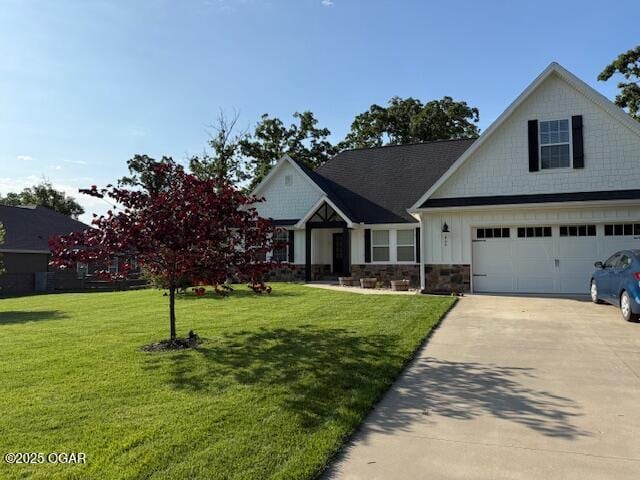 409 Dogwood Trail Loop, Carl Junction, MO 64834 - view of front of house with driveway, a front yard, stone siding, and board and batten siding