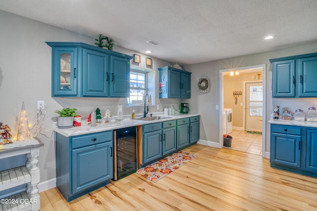 2228 Possum Trot Rd, Billings, MO 65610 - kitchen featuring beverage cooler, a sink, blue cabinets, a textured ceiling, and recessed lighting