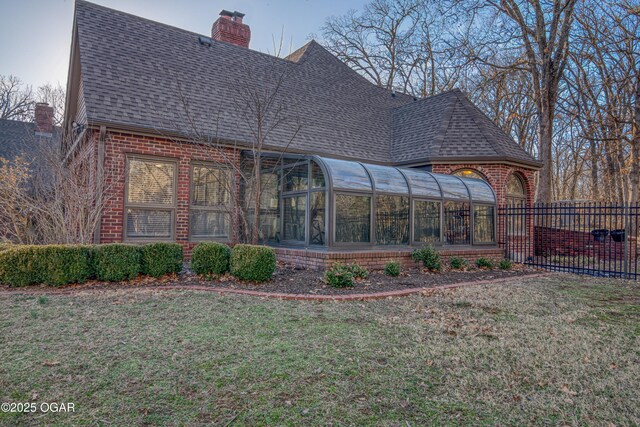4 Emerald Dr, Joplin, MO 64804 - rear view of house featuring a sunroom, roof with shingles, brick siding, and a chimney