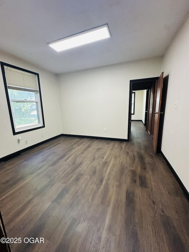 1926 S Main St, Carthage, MO 64836 - empty room featuring dark wood-style floors and baseboards