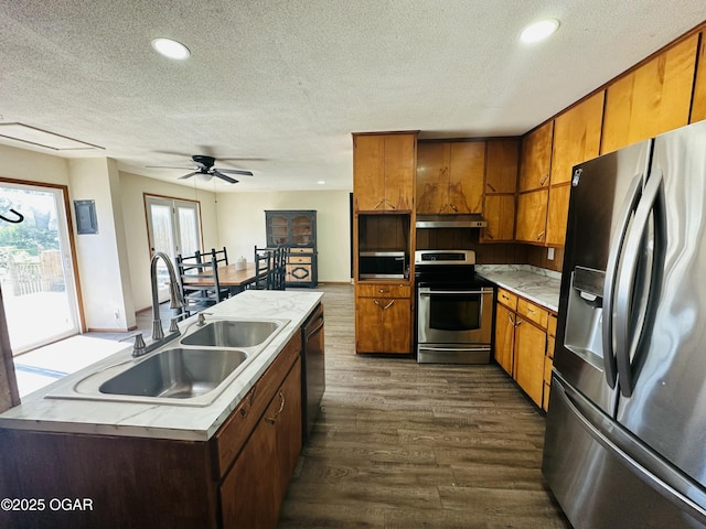 1926 S Main St, Carthage, MO 64836 - kitchen featuring stainless steel appliances, a sink, under cabinet range hood, a textured ceiling, and dark wood-style floors
