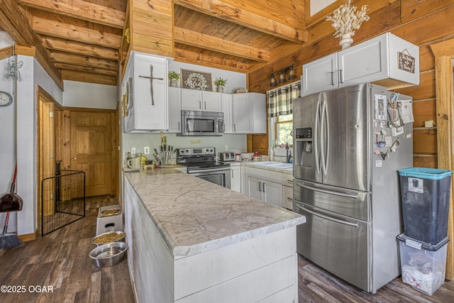 3219 Hughes Ave, Parsons, KS 67357 - kitchen featuring stainless steel appliances, white cabinets, a peninsula, wood ceiling with exposed beams, and dark wood-style floors