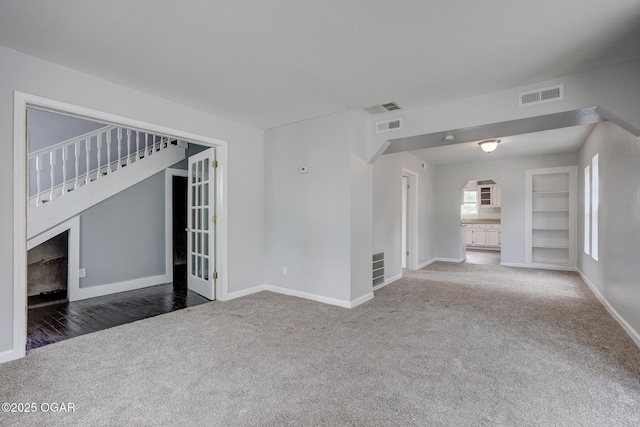 109 N Main St, Alba, MO 64830 - unfurnished room featuring carpet, baseboards, built in shelves, and arched walkways