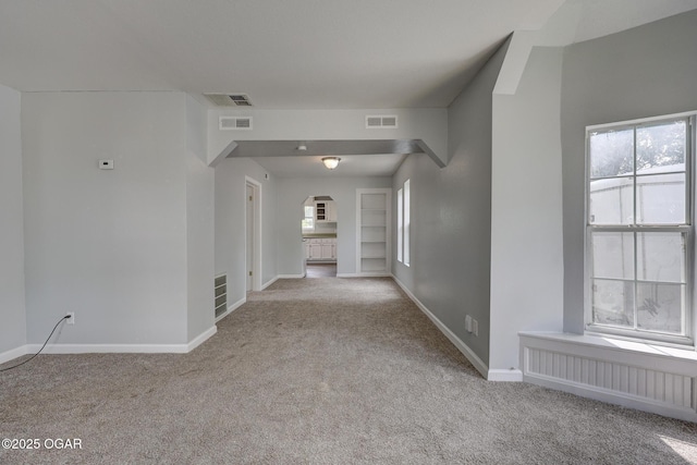 109 N Main St, Alba, MO 64830 - carpeted spare room featuring arched walkways, baseboards, and radiator heating unit
