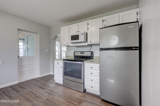 109 N Main St, Alba, MO 64830 - kitchen with stainless steel appliances, white cabinetry, light countertops, and wood finished floors