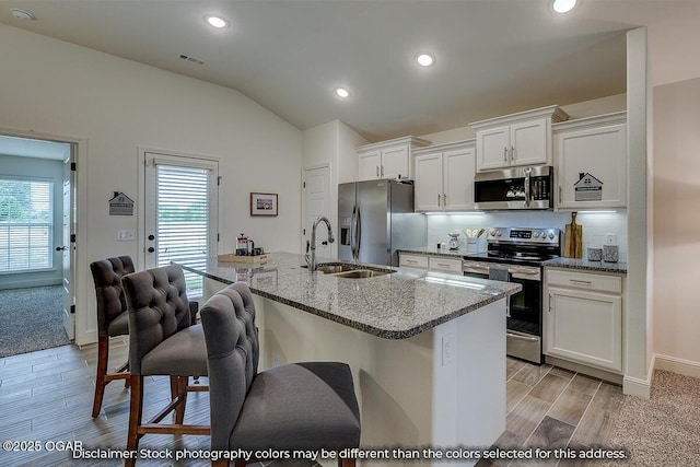 1619 Sedge St, Joplin, MO 64801 - kitchen featuring stainless steel appliances, a sink, white cabinets, a kitchen breakfast bar, and backsplash