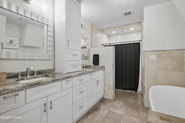 5594 Riverside Dr, Joplin, MO 64804 - bathroom featuring tile walls, double vanity, tiled shower, a freestanding tub, and recessed lighting