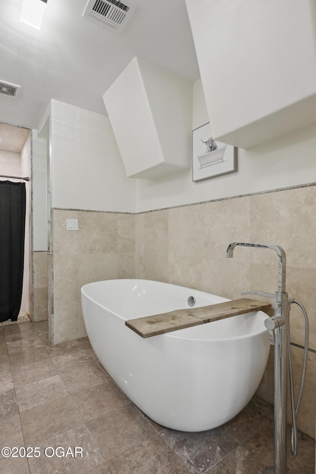 5594 Riverside Dr, Joplin, MO 64804 - bathroom with tile walls, a soaking tub, and a wainscoted wall
