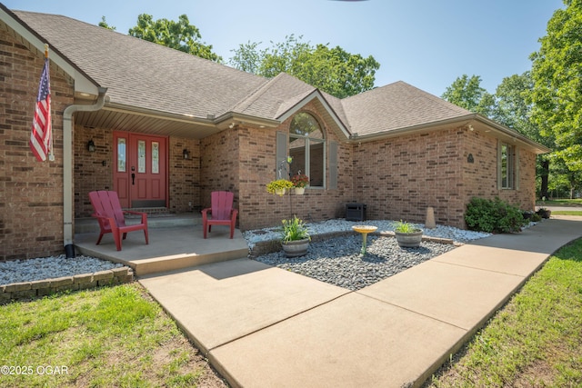 2402 Melissa Ln, Joplin, MO 64804 - doorway to property with brick siding, a shingled roof, covered porch, and central AC unit