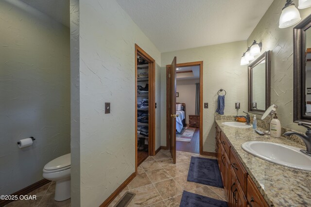2402 Melissa Ln, Joplin, MO 64804 - full bathroom with double vanity, toilet, a textured ceiling, tile patterned floors, and a textured wall