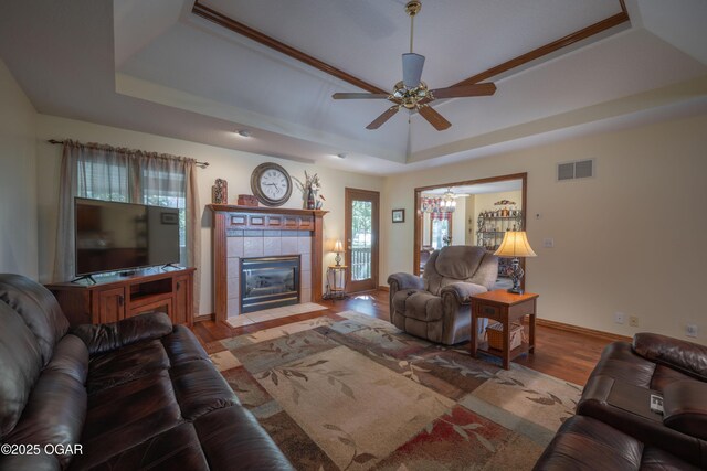 2402 Melissa Ln, Joplin, MO 64804 - living area featuring a tray ceiling, wood finished floors, a ceiling fan, a tile fireplace, and baseboards
