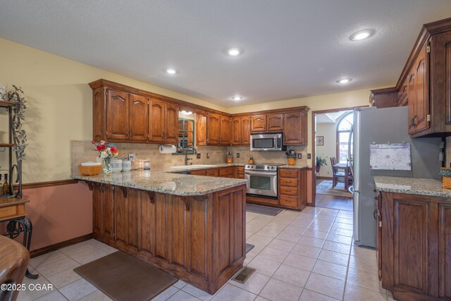 2402 Melissa Ln, Joplin, MO 64804 - kitchen featuring stainless steel appliances, a peninsula, a sink, light tile patterned floors, and recessed lighting