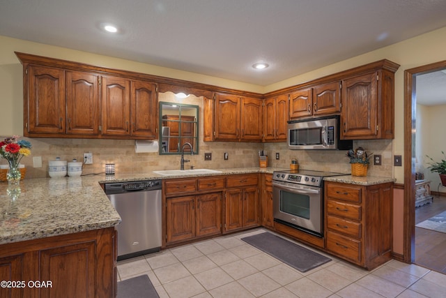 2402 Melissa Ln, Joplin, MO 64804 - kitchen with appliances with stainless steel finishes, a sink, tasteful backsplash, light stone countertops, and recessed lighting