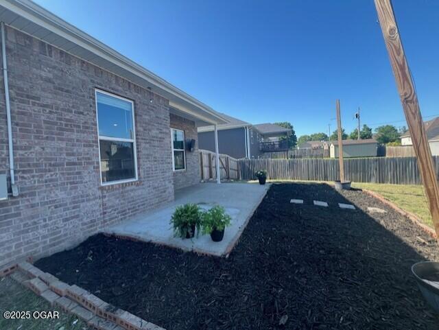 305 Ashmore Dr, Carl Junction, MO 64834 - fenced backyard with a patio
