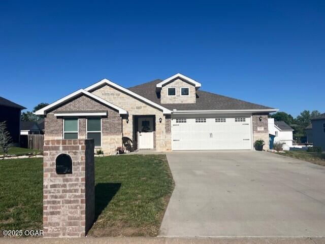 305 Ashmore Dr, Carl Junction, MO 64834 - view of front of house with a garage, a front lawn, driveway, and brick siding