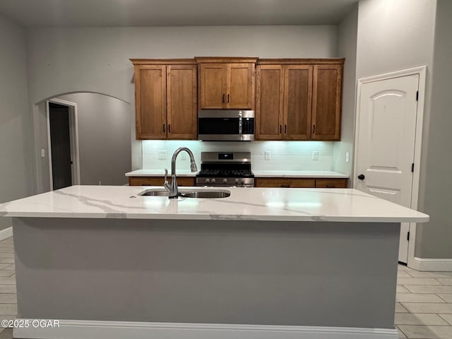 305 Ashmore Dr, Carl Junction, MO 64834 - kitchen featuring appliances with stainless steel finishes, a sink, backsplash, and arched walkways