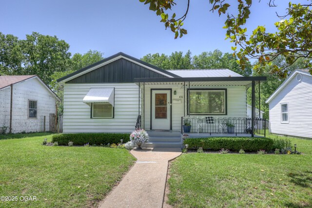 430 N Jackson Ave, Joplin, MO 64801 - view of front of home with covered porch, a front lawn, and board and batten siding