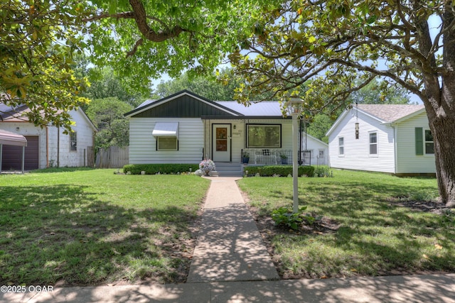 430 N Jackson Ave, Joplin, MO 64801 - view of front of property featuring covered porch, a front yard, and board and batten siding