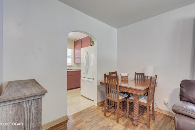430 N Jackson Ave, Joplin, MO 64801 - dining area featuring arched walkways, light wood-style flooring, and baseboards