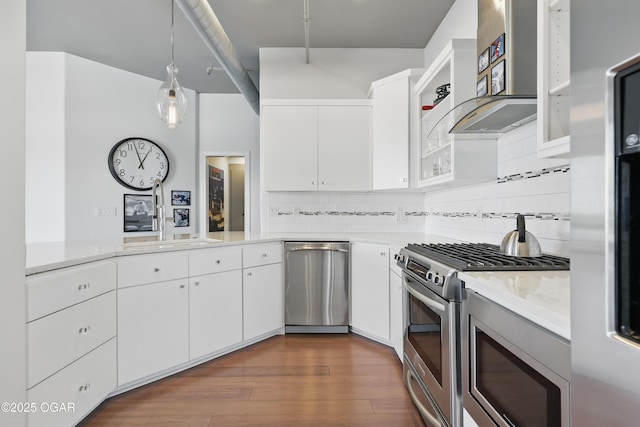214 E 4th St Unit 402, Joplin, MO 64801 - kitchen featuring stainless steel appliances, backsplash, wall chimney range hood, light countertops, and white cabinets