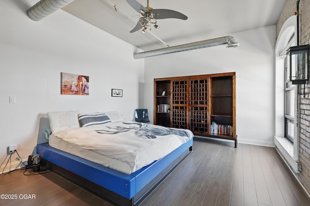 214 E 4th St Unit 402, Joplin, MO 64801 - bedroom featuring multiple windows, wood finished floors, a wall mounted air conditioner, and baseboards