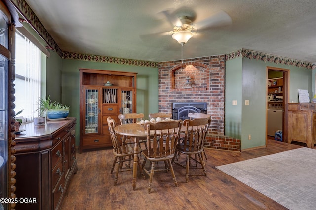 610 N Madison St, Webb City, MO 64870 - dining area with a brick fireplace, dark wood finished floors, ceiling fan, and baseboards