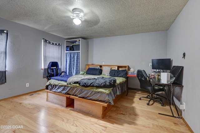 610 N Madison St, Webb City, MO 64870 - bedroom featuring a textured ceiling, an office area, wood finished floors, and baseboards
