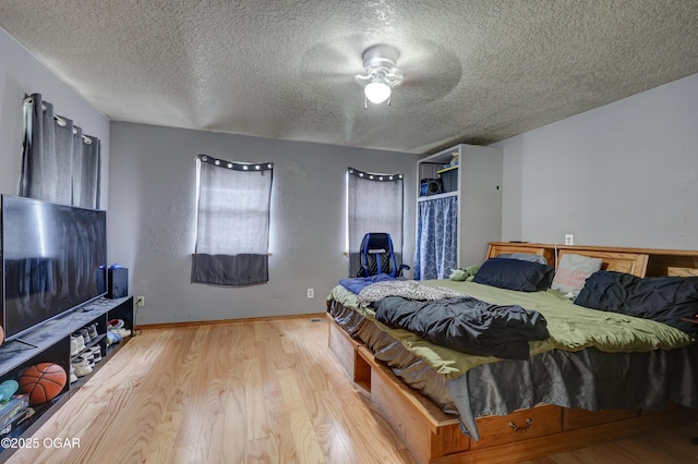 610 N Madison St, Webb City, MO 64870 - bedroom featuring wood finished floors, a textured ceiling, baseboards, and a ceiling fan