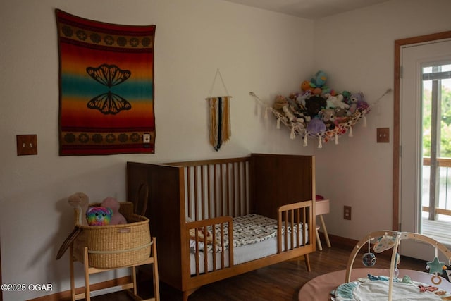 411 N Main St, Diamond, MO 64840 - bedroom featuring wood finished floors, a crib, and baseboards