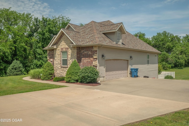 20951 Jasmine Ln, Webb City, MO 64870 - view of home's exterior featuring a shingled roof, a lawn, concrete driveway, a garage, and stone siding