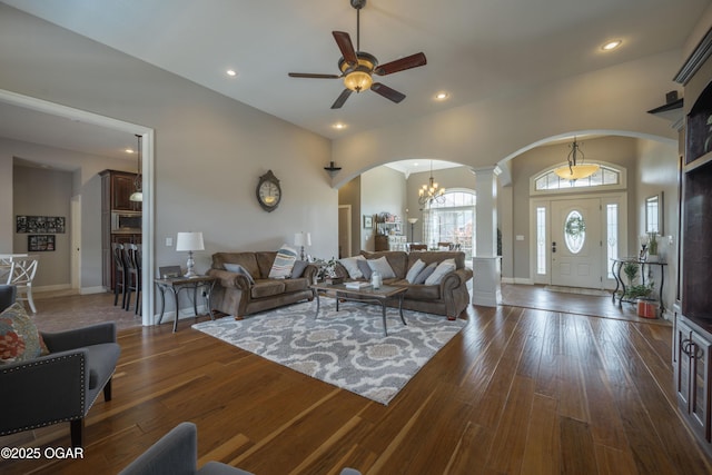 20951 Jasmine Ln, Webb City, MO 64870 - living room with arched walkways, ornate columns, ceiling fan, dark wood-style flooring, and a chandelier