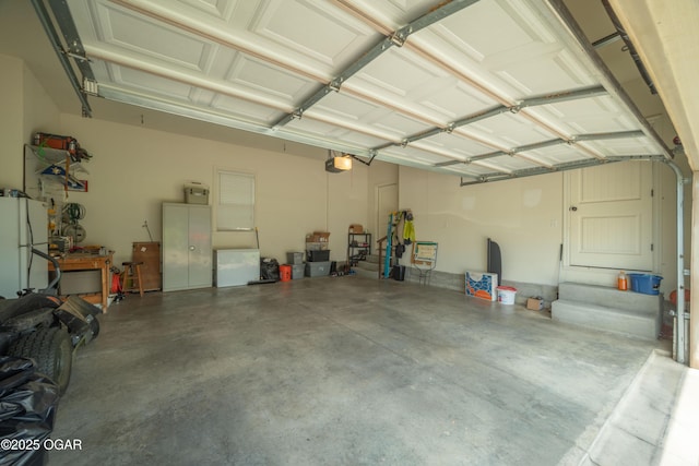 20951 Jasmine Ln, Webb City, MO 64870 - garage with a garage door opener and freestanding refrigerator