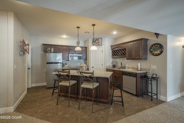 20951 Jasmine Ln, Webb City, MO 64870 - kitchen featuring stainless steel appliances, dark brown cabinets, a kitchen breakfast bar, a sink, and a kitchen island