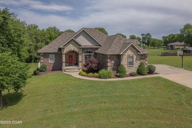 20951 Jasmine Ln, Webb City, MO 64870 - craftsman-style house with a front lawn, stone siding, concrete driveway, and brick siding