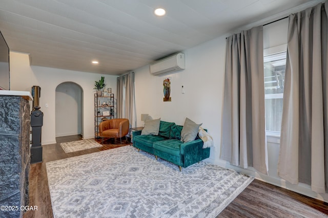 514 S Brownell Ave, Joplin, MO 64801 - living area featuring an AC wall unit, arched walkways, wood finished floors, and recessed lighting