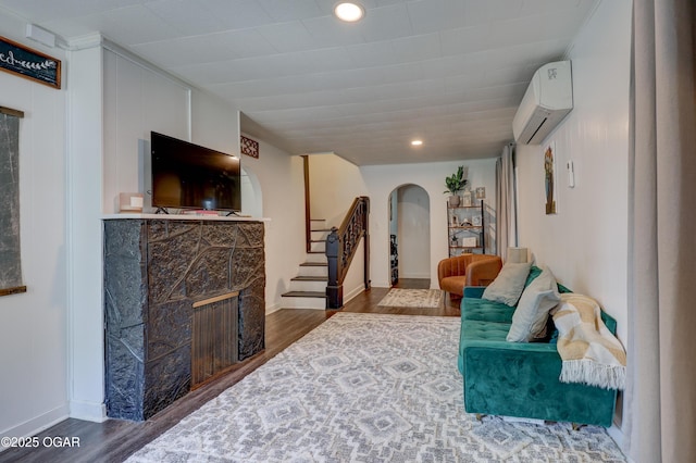 514 S Brownell Ave, Joplin, MO 64801 - living room with arched walkways, an AC wall unit, wood finished floors, stairway, and recessed lighting