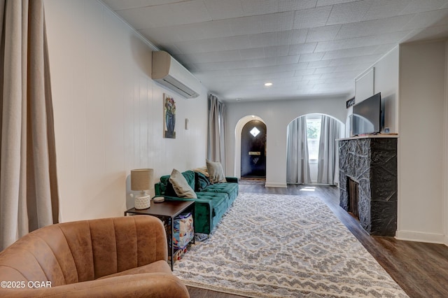 514 S Brownell Ave, Joplin, MO 64801 - living room with an AC wall unit, arched walkways, dark wood-style flooring, and a premium fireplace