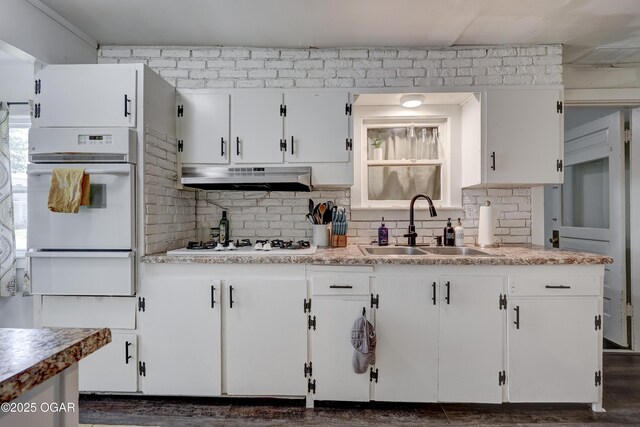 514 S Brownell Ave, Joplin, MO 64801 - kitchen featuring white appliances, under cabinet range hood, a sink, a warming drawer, and white cabinets