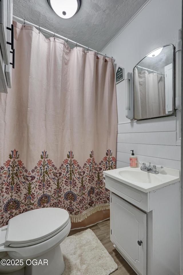 514 S Brownell Ave, Joplin, MO 64801 - bathroom featuring wood finished floors, toilet, vanity, curtained shower, and a textured ceiling