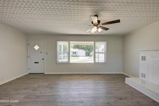 3124 Missouri Ave, Joplin, MO 64804 - unfurnished living room featuring a brick fireplace, ceiling fan, wood finished floors, and baseboards