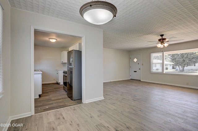 3124 Missouri Ave, Joplin, MO 64804 - unfurnished living room featuring ceiling fan, wood finished floors, and baseboards