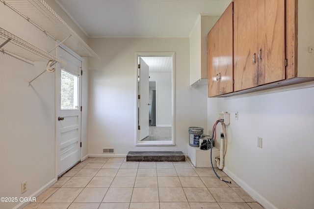 3124 Missouri Ave, Joplin, MO 64804 - laundry room featuring cabinet space, light tile patterned flooring, baseboards, and crown molding