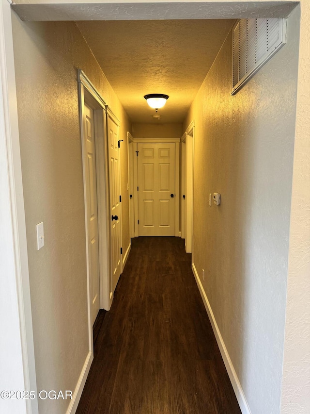 2119 S Main St, Carthage, MO 64836 - hall featuring dark wood-style flooring, baseboards, a textured wall, and a textured ceiling