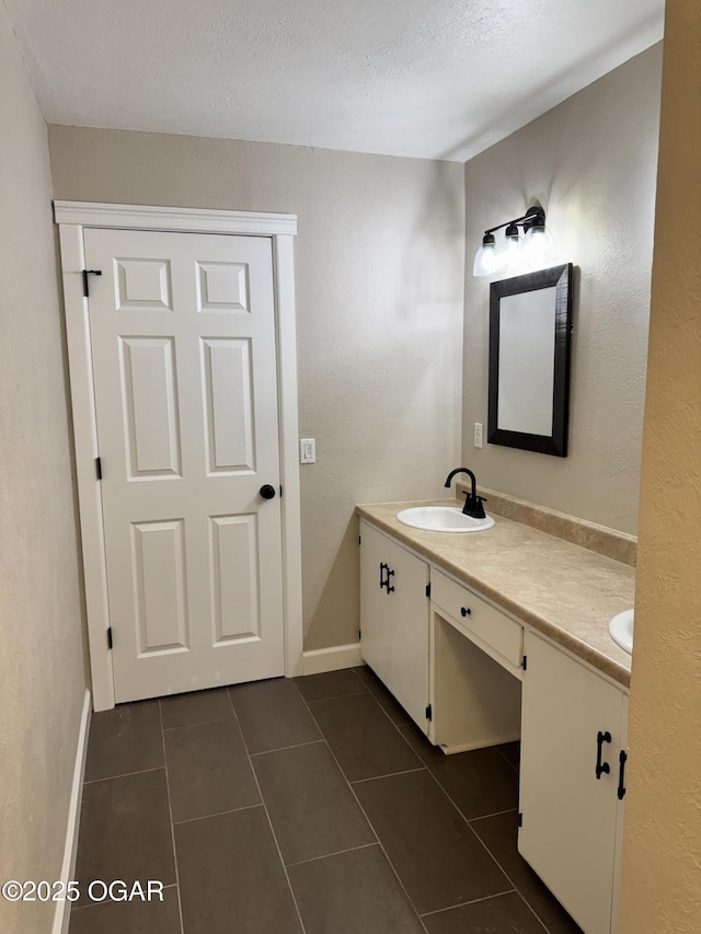 2119 S Main St, Carthage, MO 64836 - bathroom featuring double vanity, tile patterned floors, a textured ceiling, and baseboards