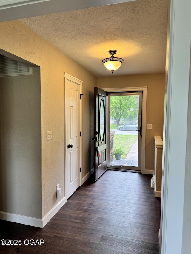 2119 S Main St, Carthage, MO 64836 - entryway with baseboards, dark wood-type flooring, a textured wall, and a textured ceiling
