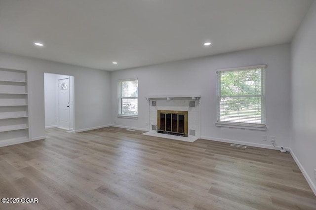 328 E 33rd St, Joplin, MO 64804 - unfurnished living room with a brick fireplace, wood finished floors, recessed lighting, baseboards, and built in shelves