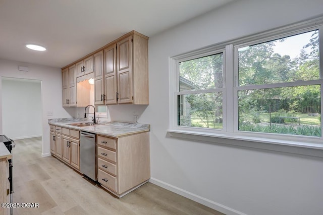 328 E 33rd St, Joplin, MO 64804 - kitchen with stainless steel dishwasher, light countertops, baseboards, a sink, and light wood finished floors