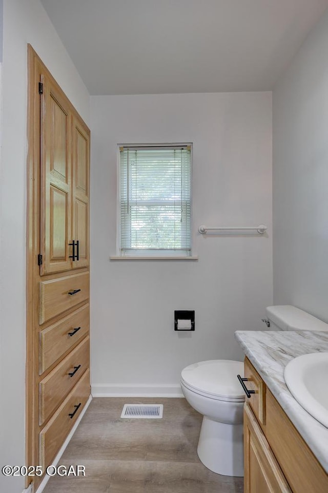 328 E 33rd St, Joplin, MO 64804 - bathroom featuring wood finished floors, vanity, toilet, and baseboards